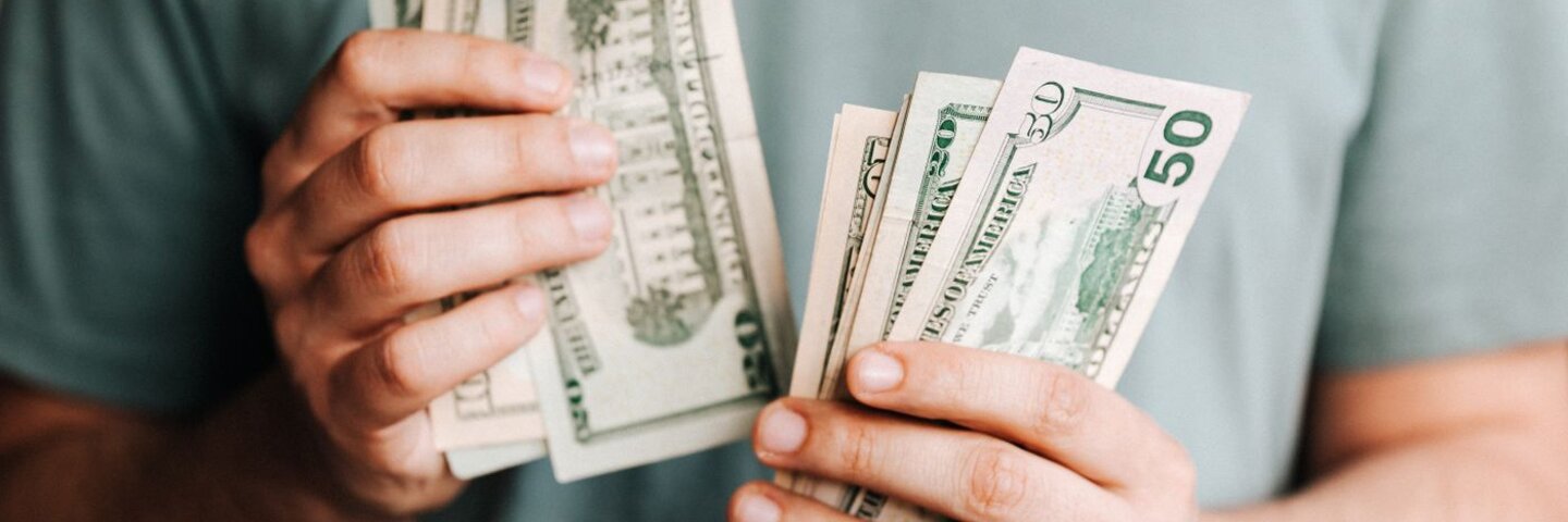 Hands counting US dollar bills