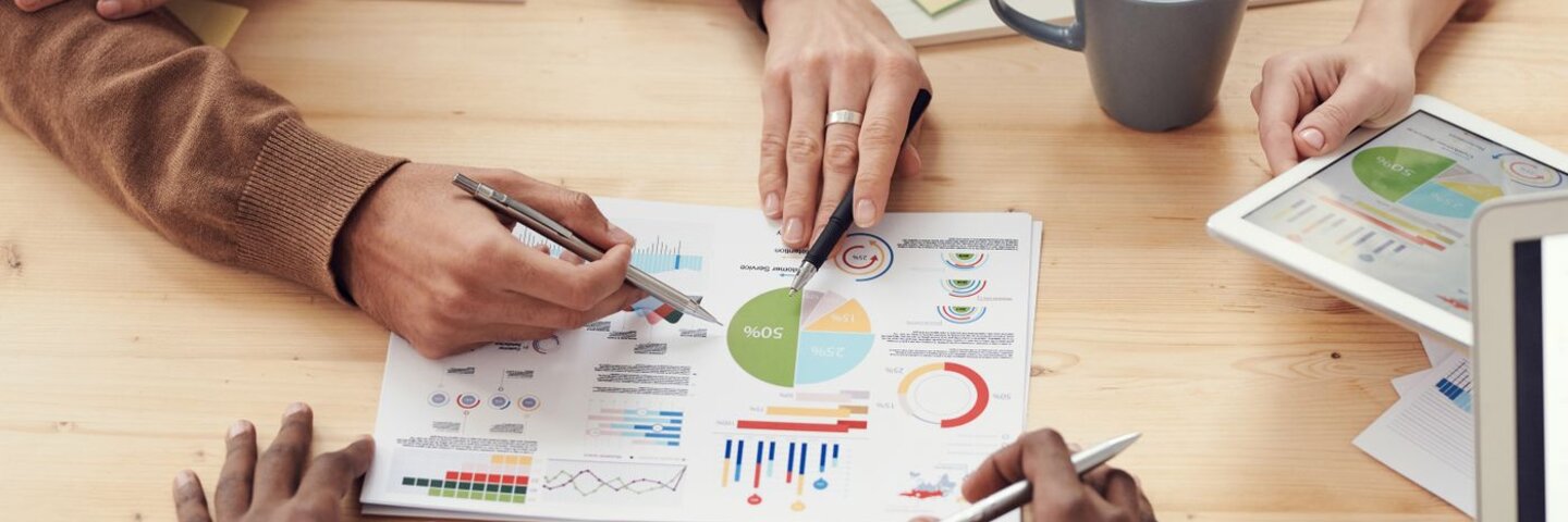 Hands reviewing charts at a meeting table