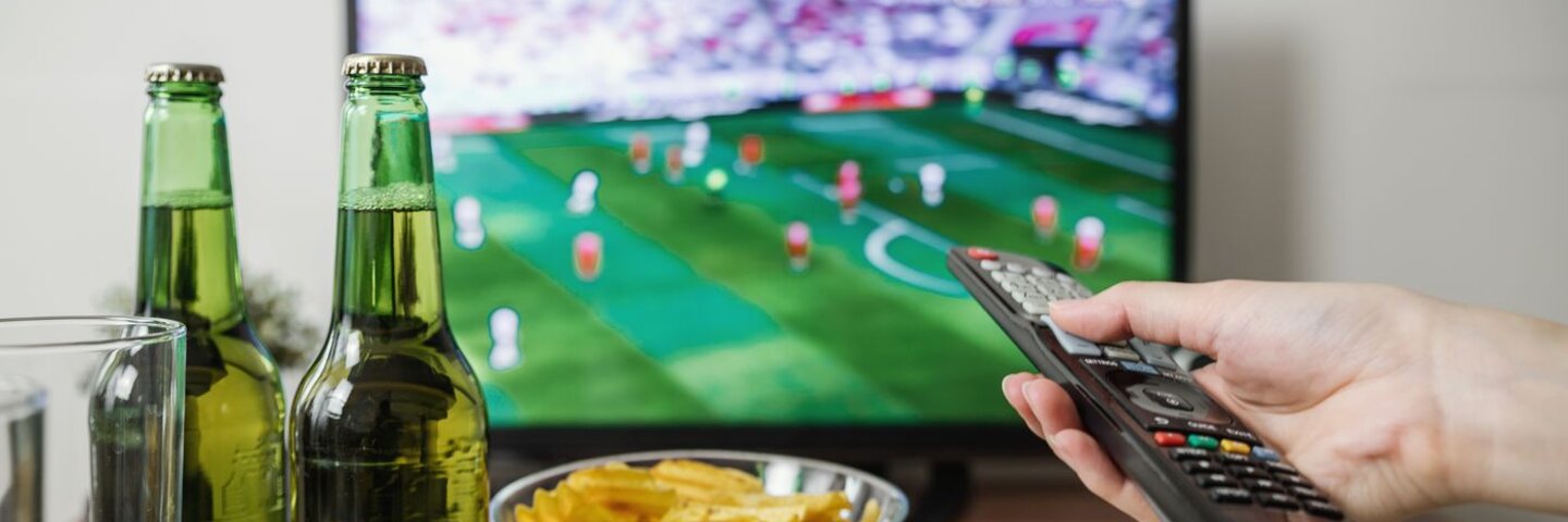 Hand pointing a remote at a living-room television