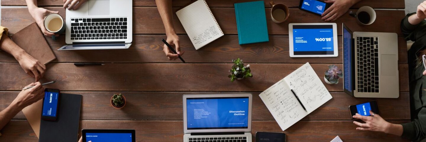 Overhead view of a meeting table with laptops and notes