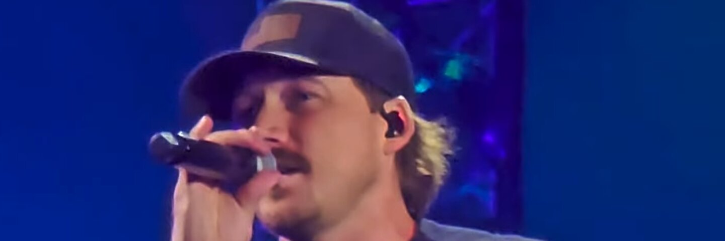 Morgan Wallen singing into a microphone on stage