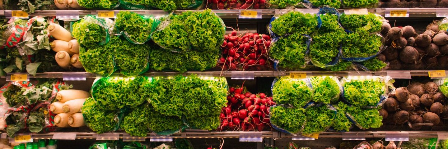 Grocery produce shelves stocked with vegetables