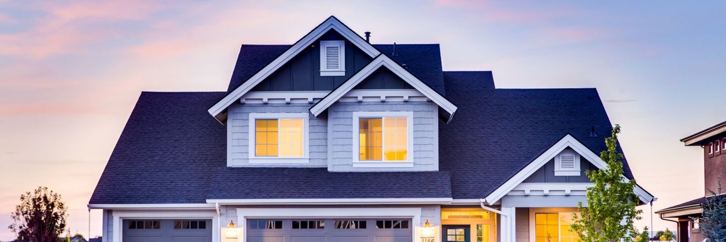 Suburban house at dusk with lit windows